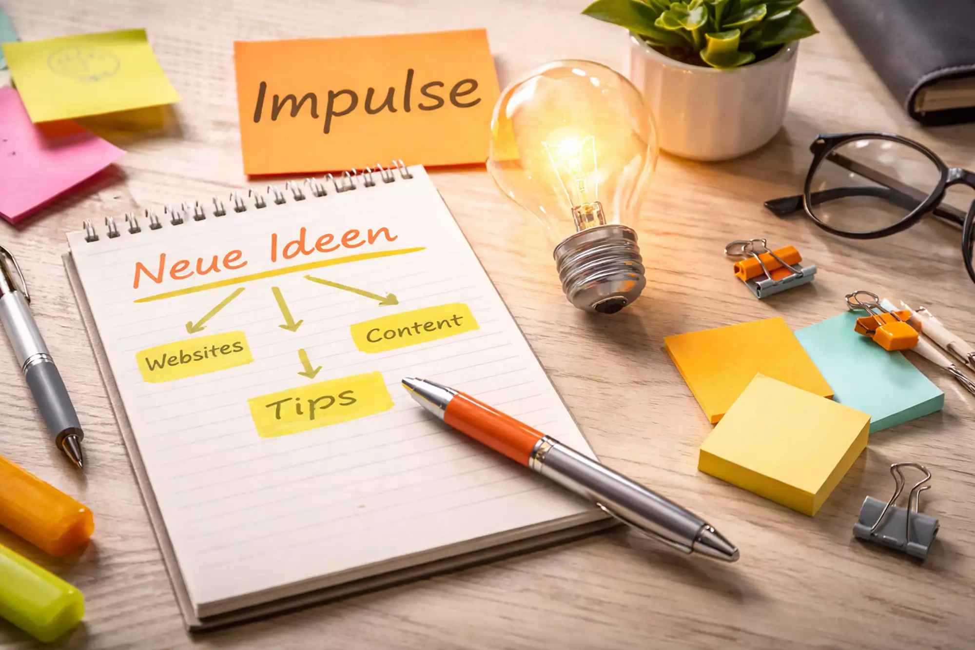Arbeitsplatz mit Notizblock, Ideen und Lichtquelle als Symbol für Impulse, Denkanstöße und Praxiswissen für bessere Websites